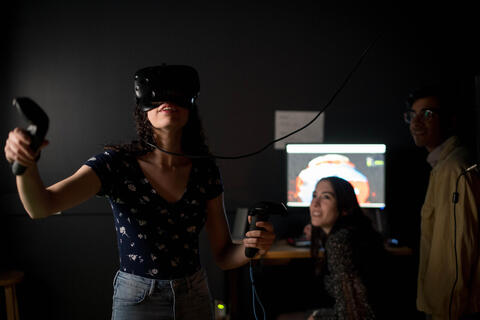 Women  wearing VR headset as two people look on 